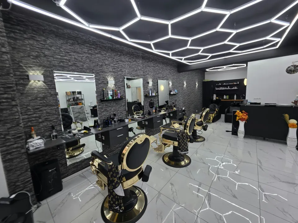 Reihe goldener Barberstühle vor Spiegeln